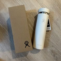 a white water bottle sitting on top of a wooden table next to a cardboard box