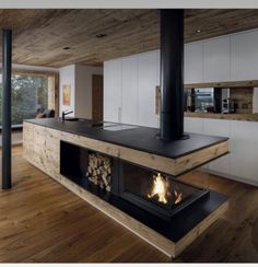 a modern kitchen with wood floors and an open fire place in the center is shown