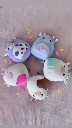 five stuffed animals laying on top of a pink blanket