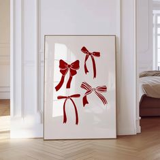 a white frame with red bows hanging on the wall