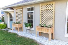 three wooden planters with plants in them sitting on the side of a house's front yard