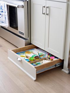 an open drawer in the middle of a kitchen