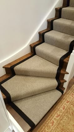 a set of stairs with carpet on the bottom and black trim around the treads