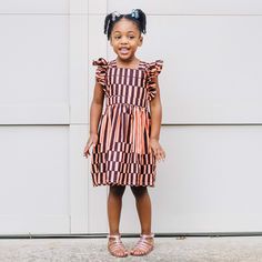 Are you tired of dresses that are nice to look at but just don't seem to provide much use? What about pieces that your little one grows out of before you can make full use of them. Yes, I know that experience too well which is why our Artisans in Nigeria and I created the Elisa dress. The dress is made out of the softest cotton fabric It has an elastic waist and adjustable ruffled tie on the back that is not only stylish but will allow you adjust to fit The short is, your little one can continue Girls Orange Dress, Pinny Dress, Ankara Print, Kids Fashion Dress, African Print Dress, Ankara Dress, Dresses For Teens, African Dress, Kids' Dresses