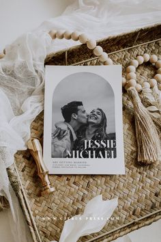 a book sitting on top of a wicker tray next to a tassel necklace