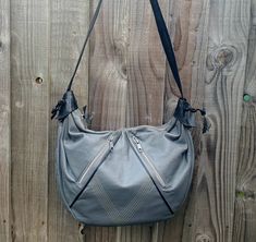 Vintage 90s mid grey leather hobo shoulder bag with black leather handle and trim.  Excellent condition no scuffing or damage to the leather lining also clean and unmarked.  Two vertical zipped pockets on the front with geometric stich design.  Black leather mid length shoulder strap.  Inside lined in black faux leather with a central divider and a secure zip pocket. Size  width  14 inches (35.5 cm)           depth  11 inches (28 cm)           shoulder strap 34 inches (86.5 cm) Gray Leather Shoulder Bag With Zipper Closure, Gray Leather Hobo Bag For Daily Use, Gray Leather Hobo Shoulder Bag, Gray Hobo Bag With Adjustable Strap, Gray Leather Hobo Bag For Everyday Use, Gray Hobo Bag With Adjustable Strap For Everyday, Gray Crossbody Hobo Bag For Everyday Use, Hobo Shoulder Bag, Beautiful Handbags