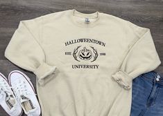 Discover Halloweentown University Embroidered Crewneck Embrace the spirit of Halloweentown with our exclusive embroidered crewneck sweatshirt! Perfect for fans of the spooky season, this cozy sweatshirt features intricate embroidery of the iconic Halloweentown University crest, showcasing a pumpkin, and a touch of magic. Product Details: Material: Soft and durable cotton blend Design: Embroidered Halloweentown University crest Sizes Available: S, M, L, XL (Unisex sizing) Whether you're heading t Halloween Cotton Pre-shrunk Sweatshirt, Casual Halloween Crew Neck Sweatshirt, Casual Crew Neck Halloween Sweatshirt, Halloween College Sweatshirt In Cotton, Halloween College Cotton Sweatshirt, Halloween Cotton College Sweatshirt, Halloween Cotton Sweatshirt For College, Halloweentown University, University Hoodie