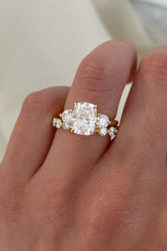 a woman's hand with three stone engagement ring