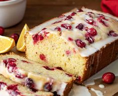 a loaf of lemon cranberry bread sitting on top of a cutting board