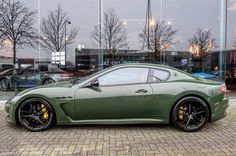 a green sports car parked in front of a building