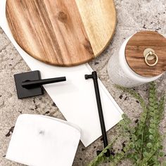 a wooden cutting board sitting on top of a table next to a knife and napkin