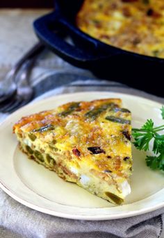 a white plate topped with a slice of quiche next to a casserole dish