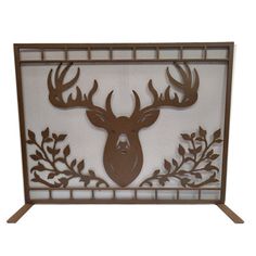 a decorative fireplace screen with a deer's head on the front and leaves on the back