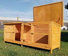 a large wooden box sitting on top of a grass covered field next to a fence