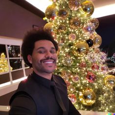 a man standing in front of a christmas tree