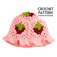 a pink crochet hat with strawberrys on the front and green leaves on the back