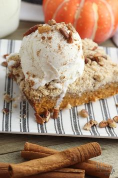 a slice of pumpkin pie on a plate with whipped cream and pecans in the background