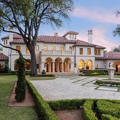 a large white house sitting next to a lush green park