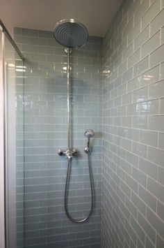 the shower head is connected to the faucet in the shower with blue tiles