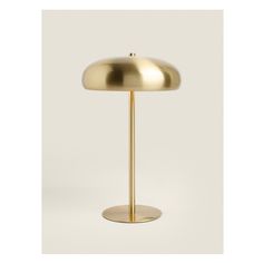 a gold colored table lamp on a white background with the light turned on and off