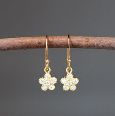 "Sweet 24k gold vermeil flower charms are set with Cubic Zirconia round stones. These dangle from 18k gold vermeil balled earwires.  These classic petite earrings are perfect for any age, and any occasion.  A wonderful gift for a young girl.  Please note these flower charms are very small.  Flower charms: 7.5x10mm Total length of earrings: 7/8\" All gold is gold vermeil, gold plating over sterling silver. A matching necklace is also available... www.etsy.com/listing/1376116208/gemstone-flower-ne Gold Dangle Flower Earrings With Cubic Zirconia, Gold Cubic Zirconia Dangle Flower Earrings, Yellow Gold Flower Cluster Earrings Gift, Yellow Gold Flower Shape Cluster Earrings For Gift, Dainty Gold-plated Flower Charm Earrings, Gold Plated Dainty Earrings With Flower Charm, Dainty Gold Plated Earrings With Flower Charm, Delicate Gold Plated Earrings With Flower Charm, Dainty Yellow Gold Earrings With Flower Charm