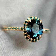 a close up of a ring with a blue and green stone on it's side