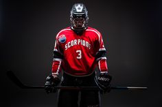 a hockey player in red jersey holding a stick