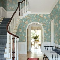 an entry way with floral wallpaper and blue stairs