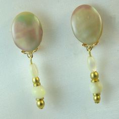 MAIAO earrings in gold metal made of genuine Vintage 1930s mother-of-pearl pearls with superb iridescent reflections and small golden pearls from the same period. Mounting on golden studs with push button. Golden metal guaranteed without nickel. Delivered in organza bag. Info +: these are old pearls from the background of a Parisian jeweler who worked in Paris in the 1920s-1950s: they are therefore all different and may have irregular shapes. Gold Clip-on Pearl Earrings, Vintage Gold Pearl Clip-on Earrings, Gold Mother Of Pearl Dangle Pearl Earrings, Gold Dangle Pearl Earrings With Mother Of Pearl, Gold Pearl Drop Earrings In Mother Of Pearl, Vintage Gold Pearl Drop Earrings, Vintage Gold Dangle Pearl Earrings, Vintage Gold Pearl Earrings, Golden Nails