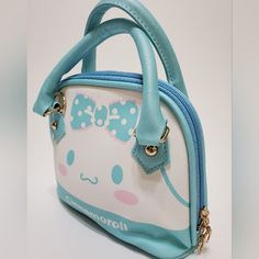 The Cinnamoroll Faux Pu Leather Handbag Is A Must-Have For Any Fashion-Forward Individual. Made With High-Quality Materials, This Handbag Features A Convenient Handle And Strap For Easy Carrying. The Iconic Cinnamoroll Design Adds A Touch Of Whimsy To Any Outfit. Elevate Your Style Game With This Versatile And Durable Handbag. Dimensions -Length 8" Inches -Height 7" Inches Cute Portable Pouch Satchel, Cute Leather Rectangular Shoulder Bag, Cute Rectangular Leather Bag, Cute Handheld Shoulder Bag With Zipper Closure, Cute Rectangular Leather Shoulder Bag, Kawaii Light Blue School Bag, Kawaii Bags With Zipper Closure For Everyday Use, Cute Blue Bag With Zipper Closure, Cute Rectangular Bag With Zipper Closure