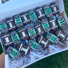 chocolate football cookies with sprinkles in a white box on the grass, ready to be eaten