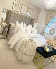 a bedroom with white bedding and chandelier