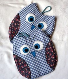 two blue and white owls are sitting on a bed with gingham cloths