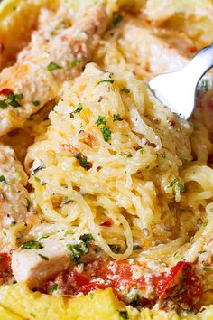 a fork in a pasta dish with meat and cheese on it, ready to be eaten