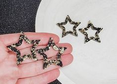 five small black and white stars are in someone's hand next to a plate