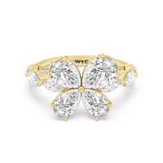 an 18k yellow gold ring with three pear shaped diamonds on the center and sides