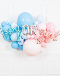 some balloons that say boy or girl and are in the shape of letters on a wall