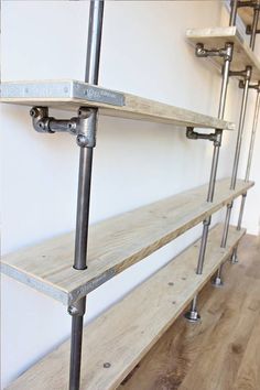 the shelves are made out of wood and metal pipe pipes with brackets on each side