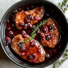 two cooked meats with cranberry sauce in a skillet on a table