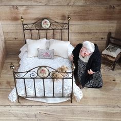 an old woman is sitting on the bed with her teddy bear in front of it