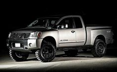 a silver truck parked in the dark with lights on it's tires and rims