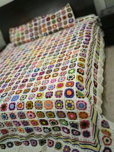 a crocheted bed spread on top of a wooden headboard