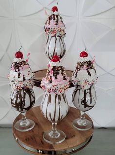 four ice cream sundaes with chocolate and sprinkles on each one