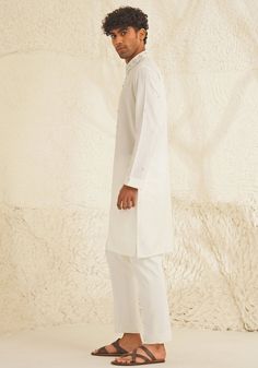 Presenting an exquisite Porcelain White Silk Kurta Set, featuring a sophisticated Chinese collar, elegant metallic silver buttons, and intricate hand-embroidered detailing on the neckline and sleeves. Paired with trendy white pants, this ensemble is perfect for engagements, Roka ceremonies, or puja events, combining timeless elegance with contemporary style. Composition : Dupion Silk Care: Dry Clean Only and Vacuum Storage This product can be customized for sleeves, length and colour Delivery : 4-6 weeks as the product is hand crafted. Check Size Guide or choose MySize for free customisation (All Sizes above XL can be made at 15% additional cost) For more information and sizes please contact fabiliciousfashion@gmail.com or visit our Copenhagen studio. About the Designer : Shreyansh, a dist Elegant Off-white Festive Sets, Elegant Straight Kurta With Set-in Sleeves, Festive Straight Kurta With Set-in Sleeves, Festive Kurta With Set-in Sleeves, Elegant Off White Sets With Chikankari Embroidery, Traditional Designer Kurta With Set-in Sleeves, Elegant Off White Embroidered Sets, Elegant Semi-formal Sets For Eid, Traditional Designer Sets With Set-in Sleeves