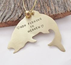 a gold necklace with a fish on it that says now fishing in heaven and has a heart