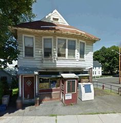 an old white house sitting on the corner of a street