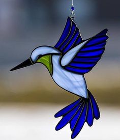 a stained glass hummingbird hanging from a chain