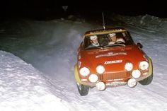 an old car driving through the snow at night