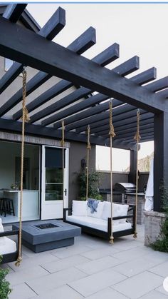 an outdoor living area with white couches and swings