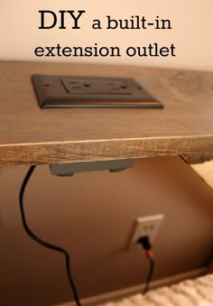 an electronic device sitting on top of a wooden table with the words diy a built - in extension outlet